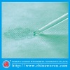 absorbent treatment nonwoven for surgical drapes